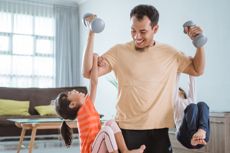 asian father use his child as weight for lifting exercise at home