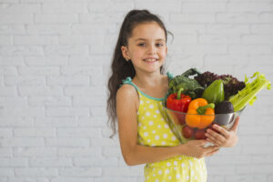 Child eating a healthy balanced meal with fruits, vegetables, milk, eggs, and whole grains to prevent nutritional deficiencies.